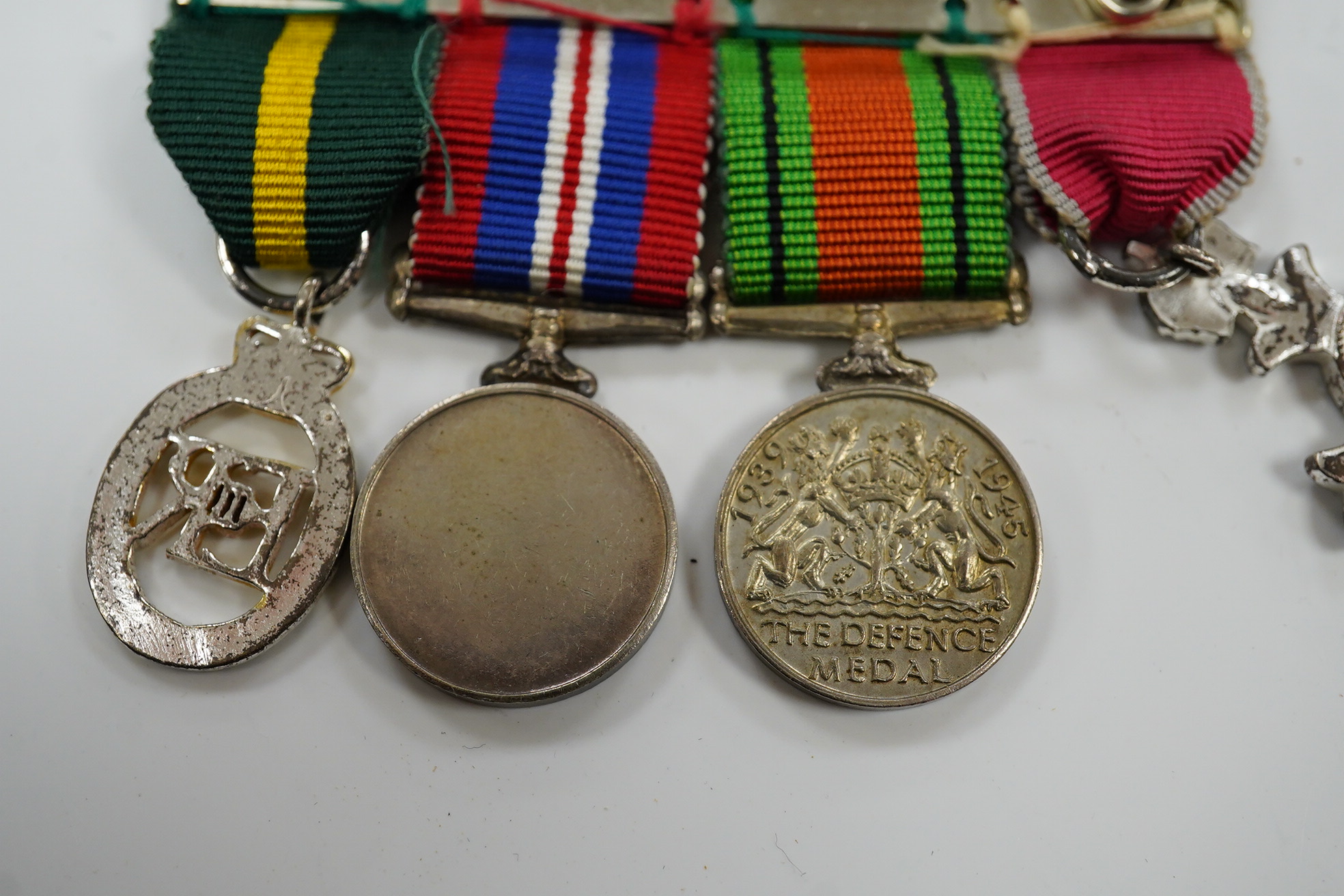 A group of 4 medals including MBE in display case